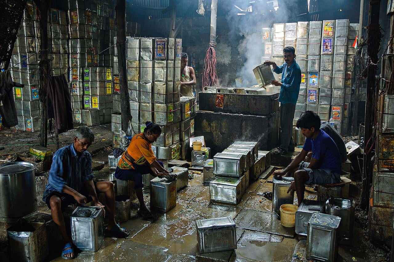Workers cleaning metal barrels for reuse in Dharavi, Mumbai
